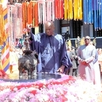 釈迦の誕生仏に水をかけて供養する国連事務総長諮問委員のドゥドゥ・ディエン博士（中央）ら＝加東市上三草