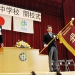 開校式での校旗授与。左は越川昌信教育長、中央は橋本衛校長＝多可中学校