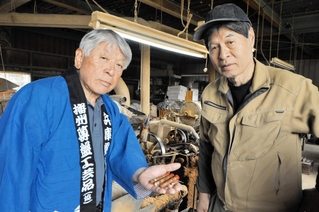 マッチ形着火剤の試作品を手にする宮永英孝さん（左）と石井清輝さん＝小野市久保木町