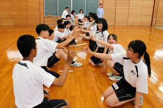 割り箸を指１本で支え合う生徒ら＝黒田庄中学校