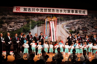 くす玉を割って工事完成を祝う関係者ら＝加東市下滝野
