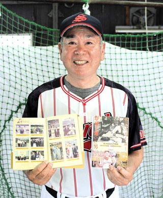 三田プリンスのユニホーム姿で今里純さんの伝記を手にする竹本武志さん＝西脇市内