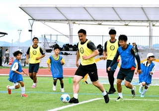子どもたちとサッカーのミニゲームを楽しむ岡崎慎司さん（中央）＝小野希望の丘陸上競技場アレオ