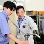 地元の電気工事士（中央）から、配線を通す金属管を曲げる作業を学ぶ生徒＝西脇市野村町