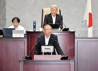 加西市の２０２６年度一般会計補正予算案を再議に付した理由を説明する高橋晴彦市長（手前）＝同市議会議場