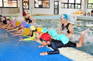 スイミングスクールのコーチから水泳を教わる泉小学校の児童たち＝サンスポーツクラブ加西
