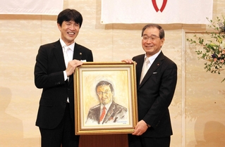 片山象三市長（左）から肖像画を受け取る十倉雅和さん＝西脇ロイヤルホテル