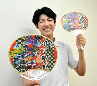 大賞に輝いたデザインのうちわを持つ上田隼大さん＝小野中学校