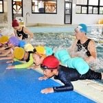 スイミングスクールのコーチから水泳を教わる泉小学校の児童たち＝サンスポーツクラブ加西
