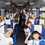 熱中症対策のバスで下校する九会小学校の児童たち＝同小
