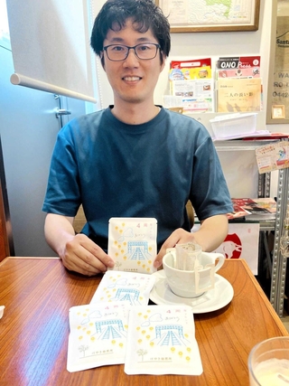 ４周年ブレンドを手にする宗平慎太郎さん＝けやき焙煎所