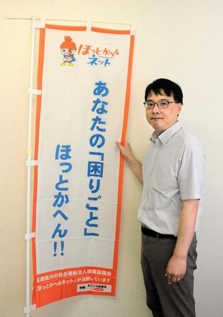 「ほっとかへんネット」ののぼりを手にする朝井誠一郎さん＝西脇市和布町