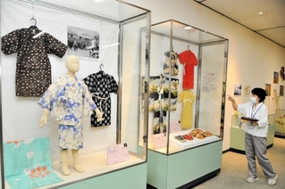 「昭和１００年　子どものくらし大図鑑」の展示を説明する藤原友子学芸員＝好古館