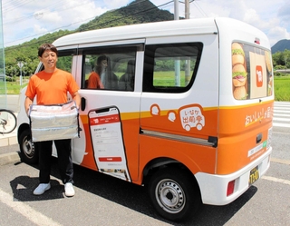 いなか出前亭をＰＲする車の前に立つ藤井英理さん＝藤井酒販
