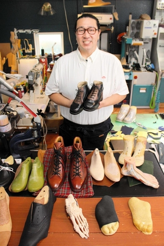 自作の靴を手にする吉田昇平さん＝多可町八千代区中野間