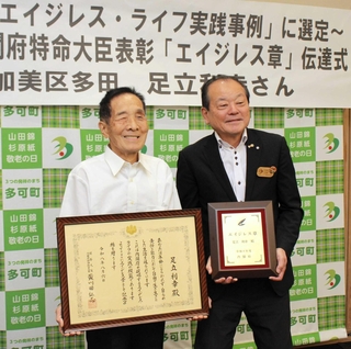 吉田一四町長（右）から書状を受け取る足立利幸さん＝多可町役場