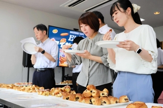 アイガーの社員らが考案したパンを食べ比べるブレインの社員ら＝西脇市鹿野町