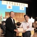 吉田一四町長（左）から記念品を受け取る参加者＝多可町中区中村町
