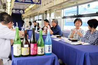 車内で日本酒や料理を楽しむ参加者＝ＪＲ西脇市駅