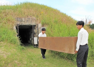 東山古墳群から木棺模型を運び出す多可高校の生徒＝多可町中区東山