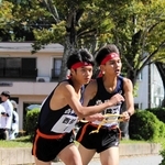 男子・西脇工の５区田渕悠真選手（右）が、６区の中川悠聖選手にたすきをつなぐ＝西脇市総合市民センター