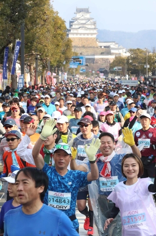 昨年の大会で、姫路城を背に笑顔でスタートするランナーら＝２０２４年２月、姫路市の大手前通り