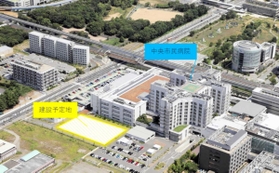 神戸市立医療センター中央市民病院と、その駐車場に整備される新型コロナ重症者専用の臨時病棟の予定地＝神戸市中央区（神戸市提供）