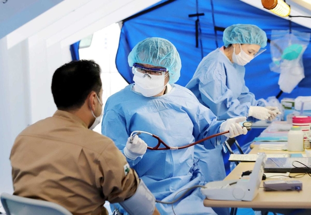 臨時テント内で発熱患者を診察する医師ら＝４月１日、西脇市下戸田、市立西脇病院