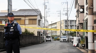 高齢男性が自宅で女に切りつけられ、死亡した現場の近く。規制線が張られ、立ち入りが制限されていた＝12日午後、尼崎市若王寺１