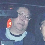 警察車両で送致される立花孝志容疑者（左）＝１０日午前９時４１分、神戸市中央区下山手通５