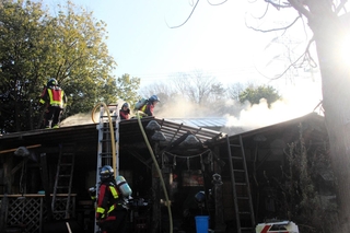 煙が上がる中、消火活動する消防署員＝三木市吉川町湯谷