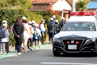 集団下校する小学校の児童らとパトロールする警察車両＝２０日午後、姫路市内