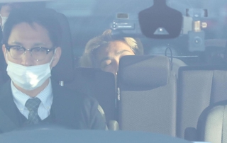 警察車両で送検される小出慶二容疑者（奥）＝２５日午前８時４５分、姫路市市之郷、姫路署