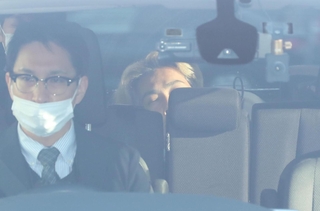 警察車両で送検される小出慶二容疑者（奥）＝２５日午前８時４５分、姫路市市之郷