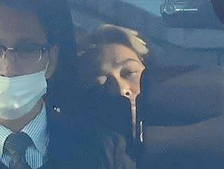 警察車両で送検される小出慶二容疑者（奥）＝２５日午前８時４５分、姫路市市之郷、姫路署