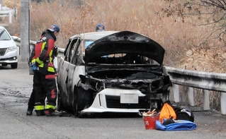 燃えた車を調べる三木署員ら＝三木市志染町大谷（画像の一部を加工しています）