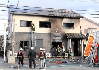 白煙がくすぶる民家で活動する消防隊員ら＝１３日午後４時４１分、姫路市白浜町宇佐崎中１