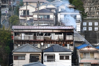 白煙を上げる木造アパート＝２８日午後５時４８分、神戸市長田区鶯町１