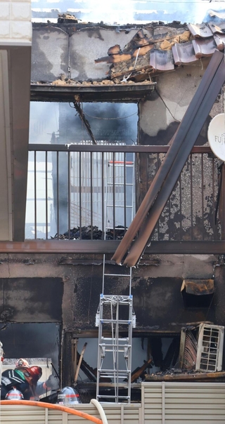 白煙を上げて燃える民家＝２９日午前、明石市大蔵八幡町