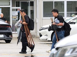 杖を手にたつの署に戻る捜査員ら＝２７日午前１１時２１分、たつの市龍野町富永
