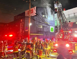 白煙を上げて燃える建物＝１８日午後９時３１分撮影、神戸市中央区脇浜町２