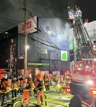 白煙を上げて燃える建物＝１８日午後９時３１分撮影、神戸市中央区脇浜町２
