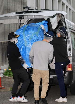 遺体が見つかった部屋から押収物を運び出す捜査員ら＝２２日午後５時３３分、神戸市中央区中山手通６
