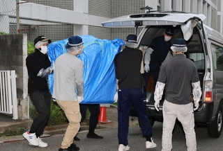 遺体が見つかった部屋から押収物を運び出す捜査員ら＝２２日午後５時３３分、神戸市中央区中山手通６