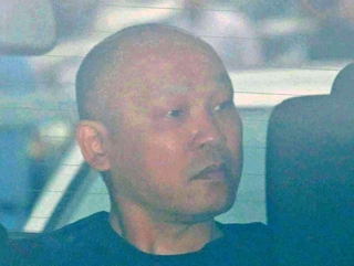 捜査車両に乗せられて長田署を出る菱川龍己容疑者＝２４日午前９時４０分、神戸市長田区北町３
