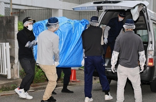 遺体が見つかった部屋から押収物を運び出す捜査員ら＝６月２２日、神戸市中央区中山手通６