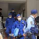 現場マンションから出てくる捜査員ら＝２１日午後５時７分、神戸市中央区中山手通６