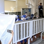 現場マンションの郵便受けを調べる捜査員ら＝２１日午前１１時５２分、神戸市中央区中山手通６