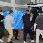 遺体が見つかった部屋から押収物を運び出す捜査員ら＝２２日午後５時３３分、神戸市中央区中山手通６