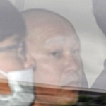 捜査車両に乗せられて長田署を出る菱川龍己容疑者＝２４日午前９時４０分、神戸市長田区北町３